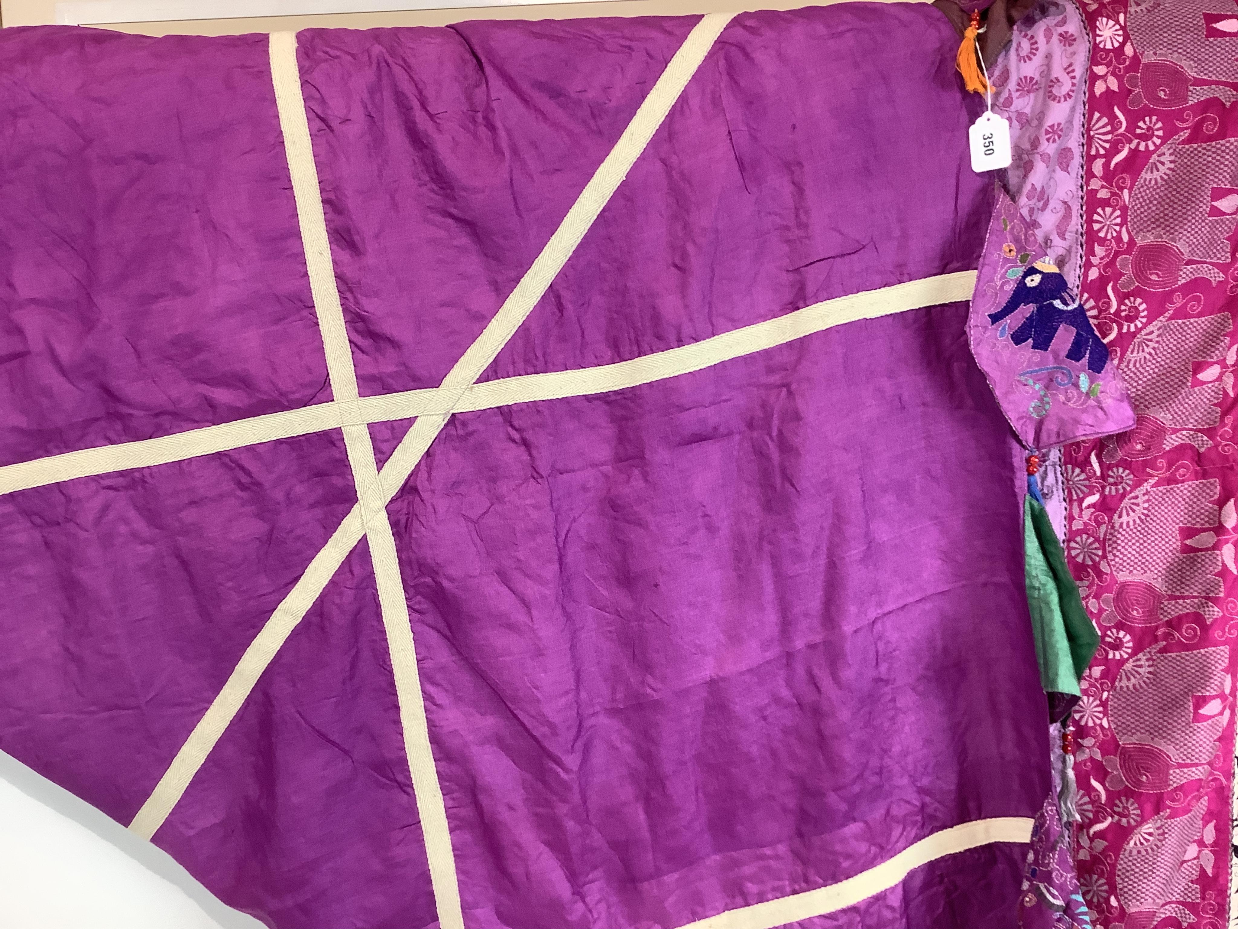 An Indian 20th century embroidered silk hanging, with decorative triangular tasselled edges. Worked in colourful silk stripes, with varying silk embroidered all over motifs. Bordered with colourful silk, beaded, tasselle
